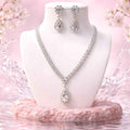 Diamond teardrop necklace with matching drop earrings on white display