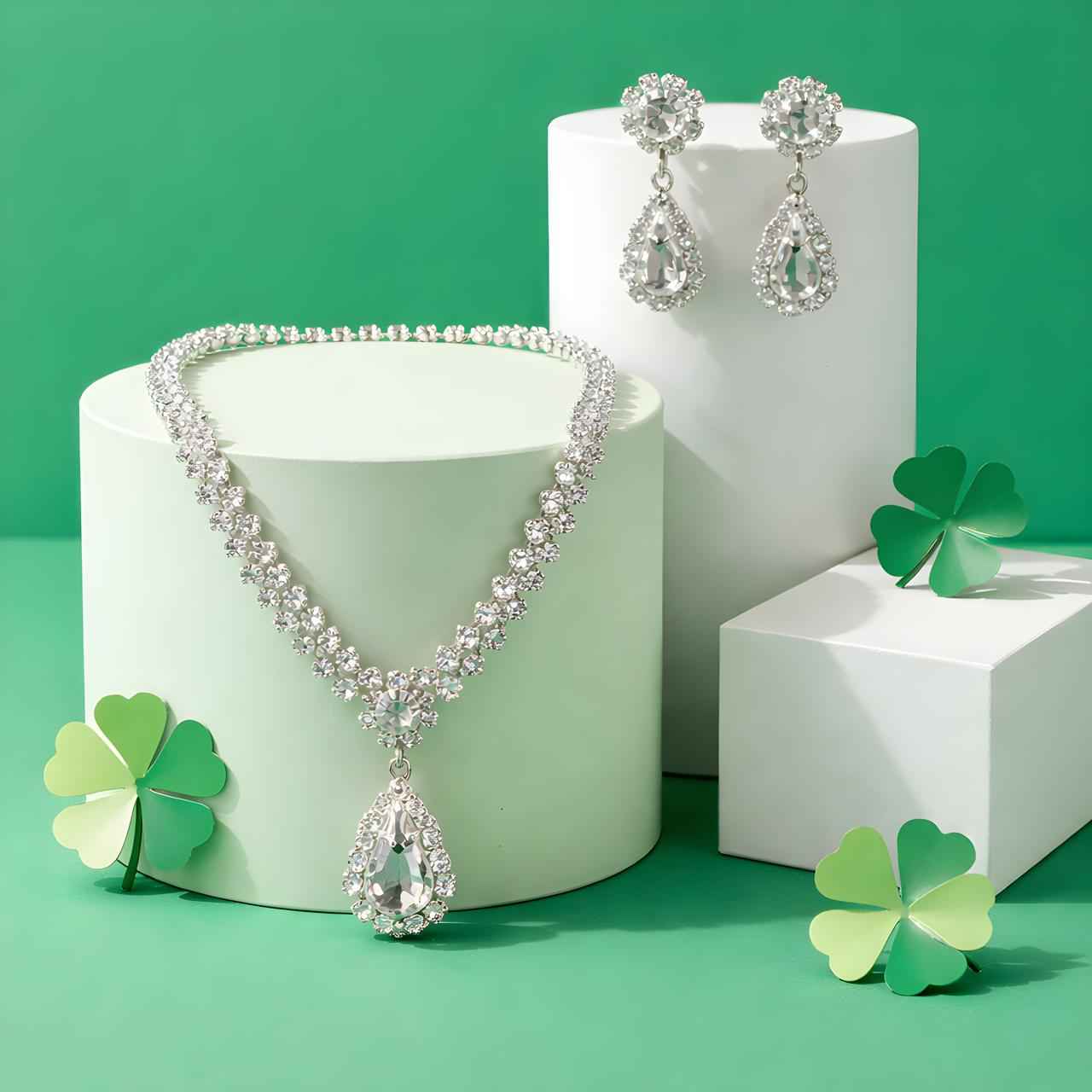 Sparkling teardrop pendant necklace and drop earrings set on pedestals