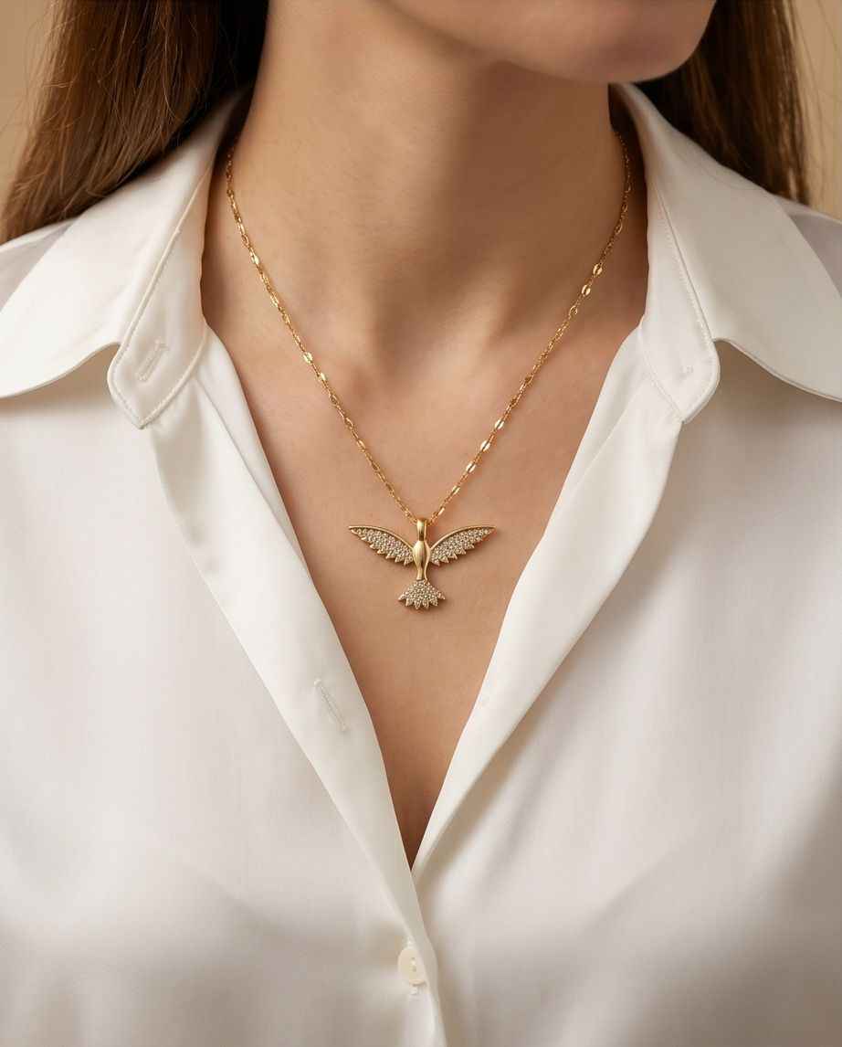 Gold bird pendant necklace with long fine-link chain and sculpted wings
