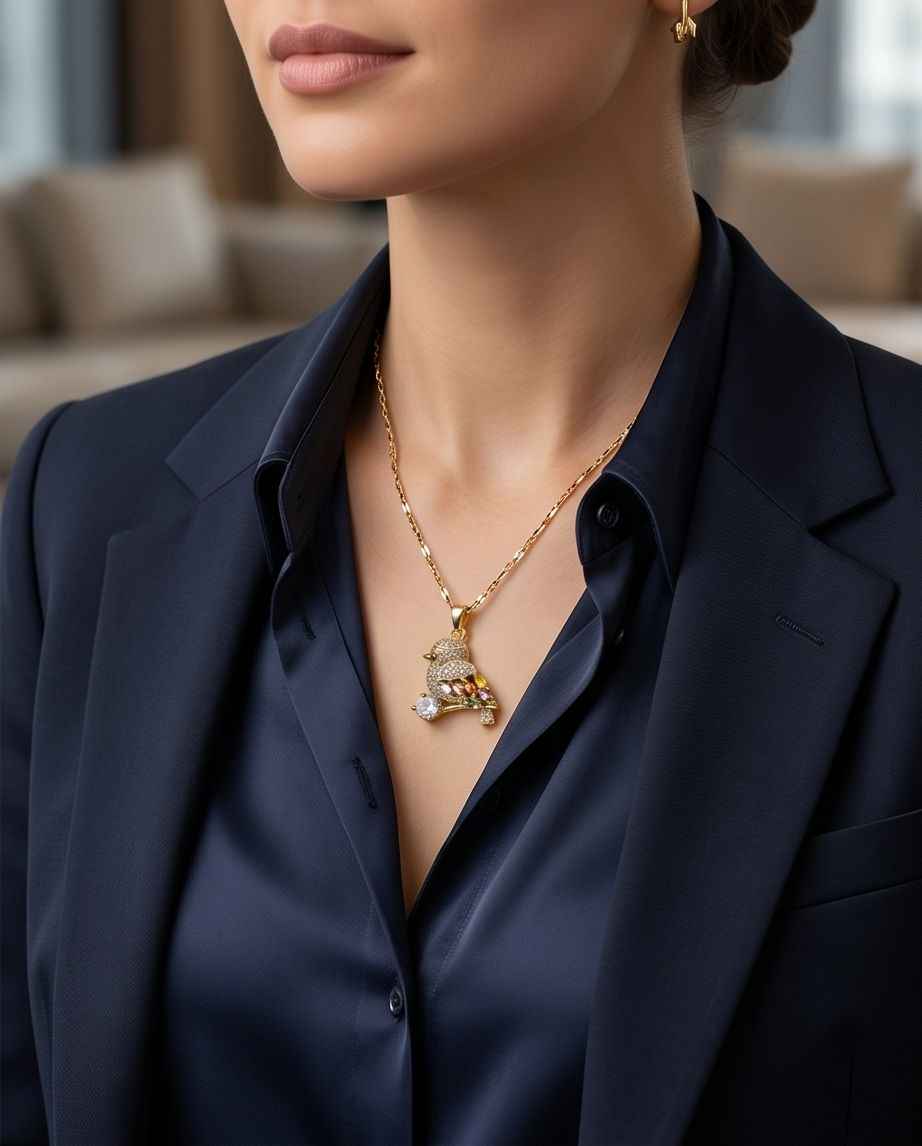 Gold-tone bird motif pendant necklace worn on neckline with link chain