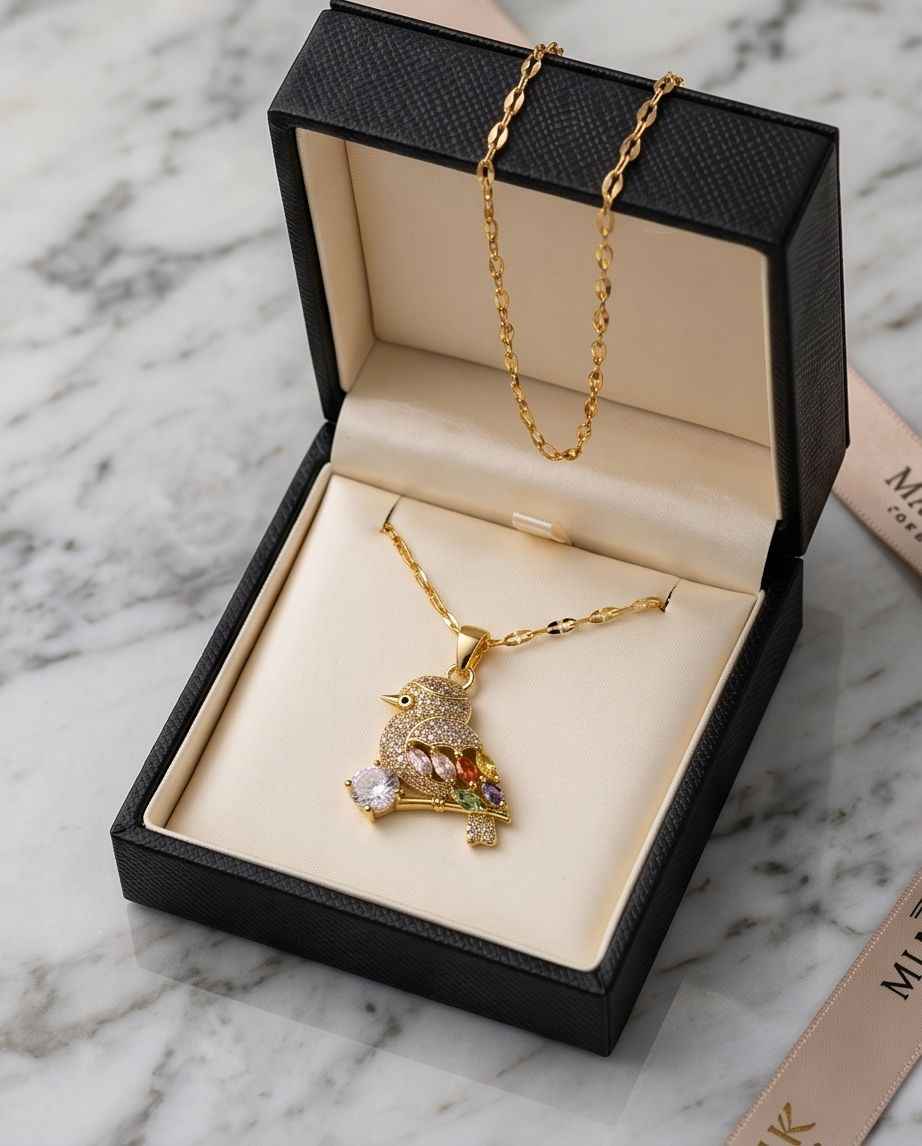 Gold-tone bird pendant necklace with multicolor gemstone details and link chain