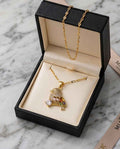Gold-tone bird pendant necklace with multicolor gemstone details and link chain