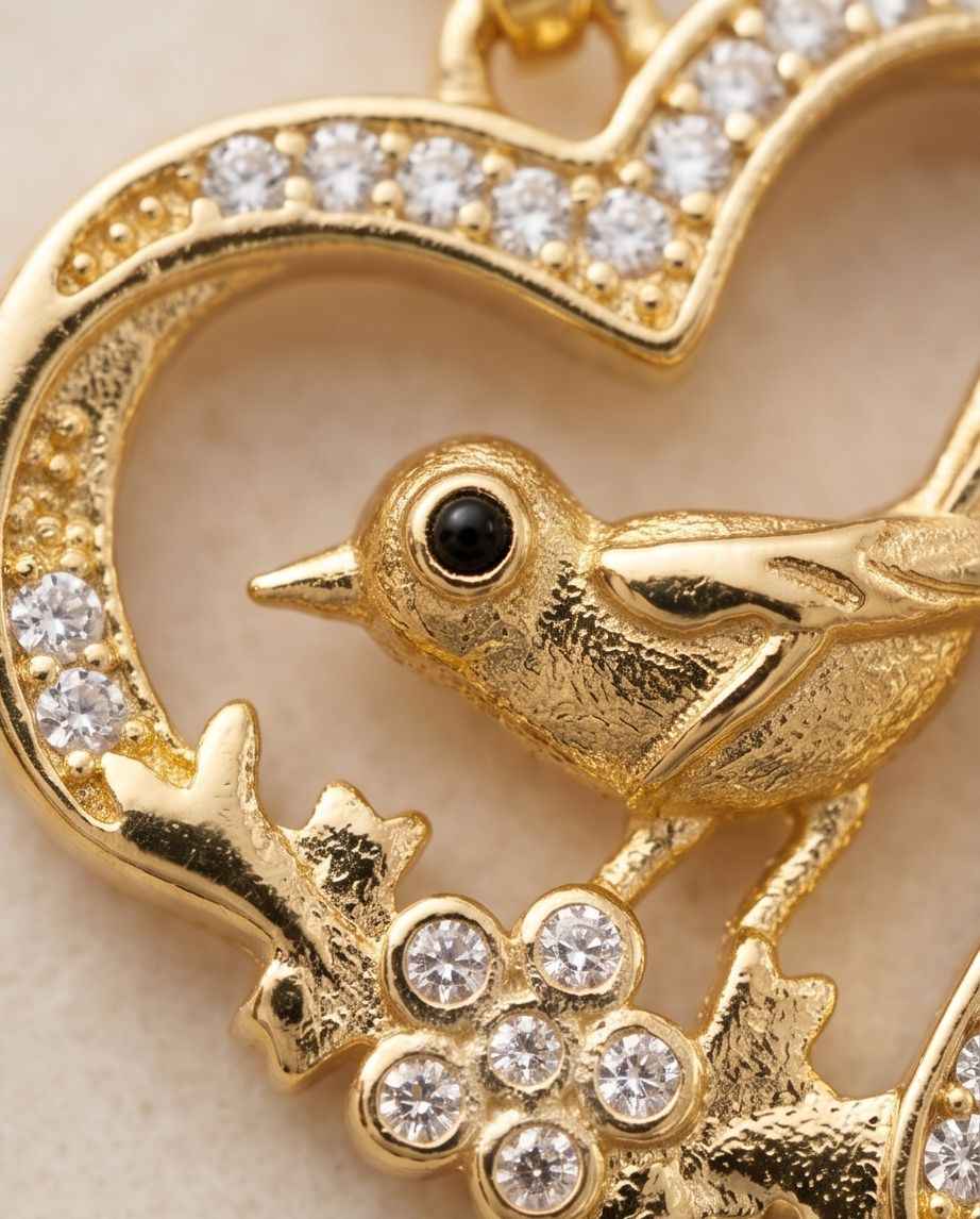 Gold bird in heart pendant with black eye and crystal pavé accents