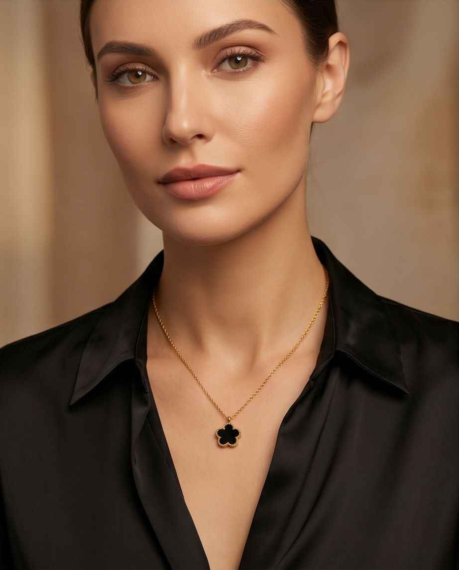 Gold clover pendant necklace worn on a model with a black collar