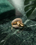 Gold-tone crossover ring with pavé set clear stones in curved double band