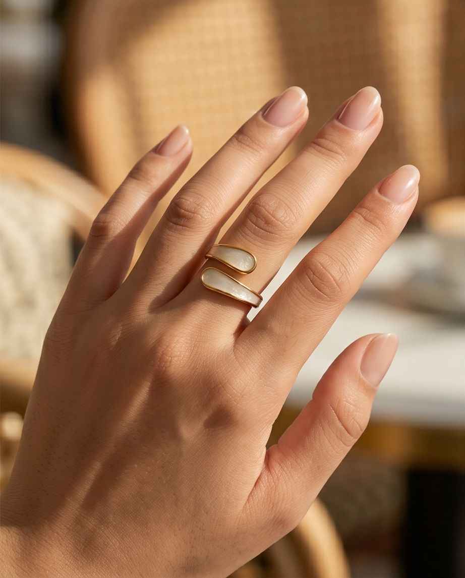 Gold crossover ring with white inlay worn on finger