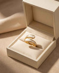 Gold crossover ring with white inlay in a gift box