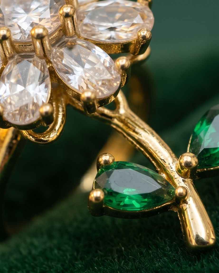 Gold ring detail with clear marquise stones and green teardrop accents