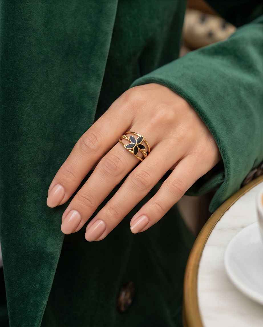 Gold open fleur ring with black enamel petals worn on finger