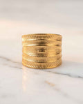 Gold textured statement ring with embossed sunburst and leaf-like grooves