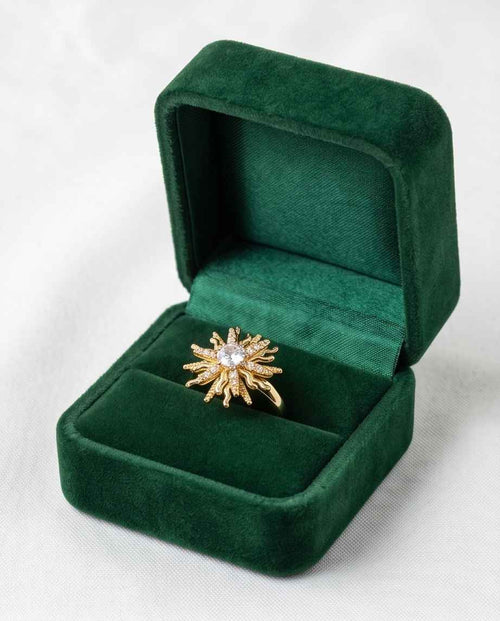 Gold statement ring with starburst cluster of clear stones, shown in green ring box