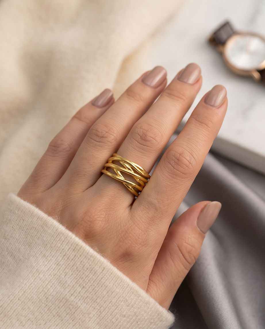 Gold intertwined statement ring on hand, openwork stacked bands