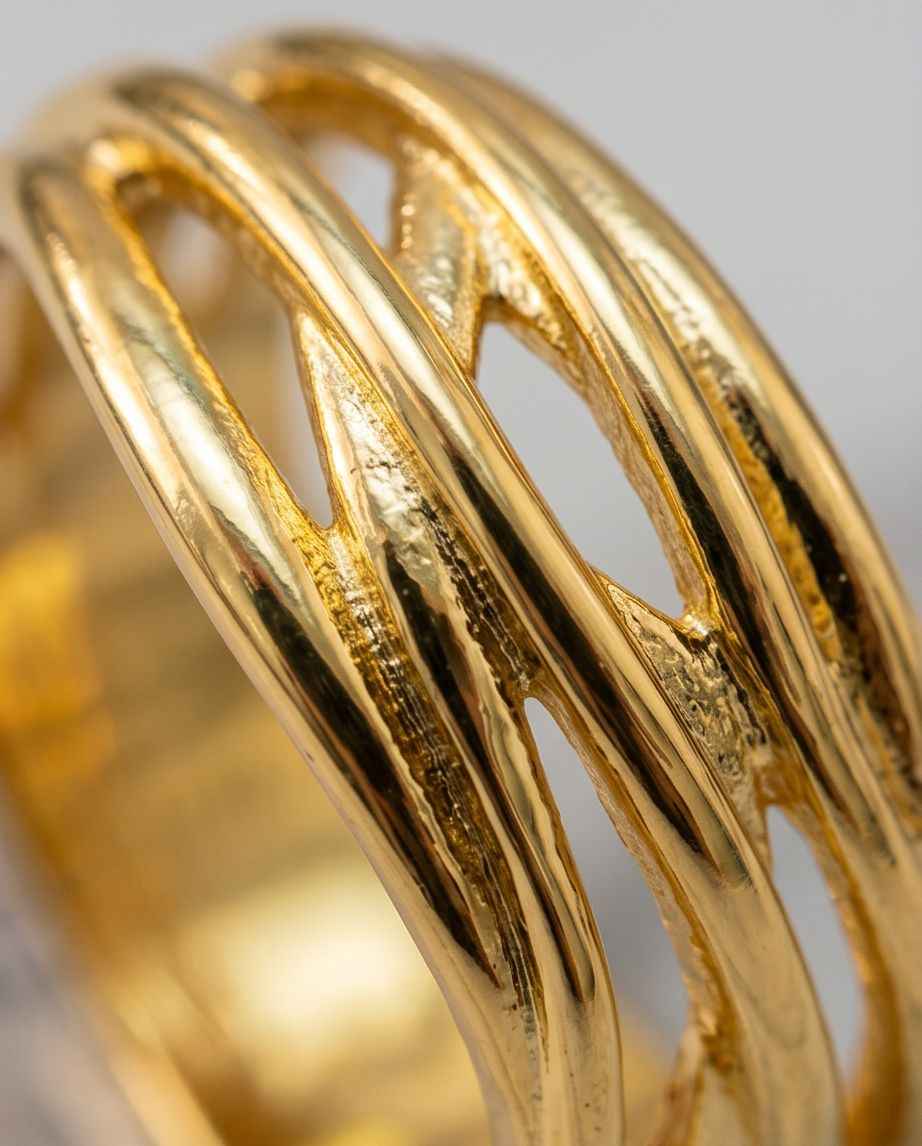 Gold statement ring with intertwined openwork bands and polished finish