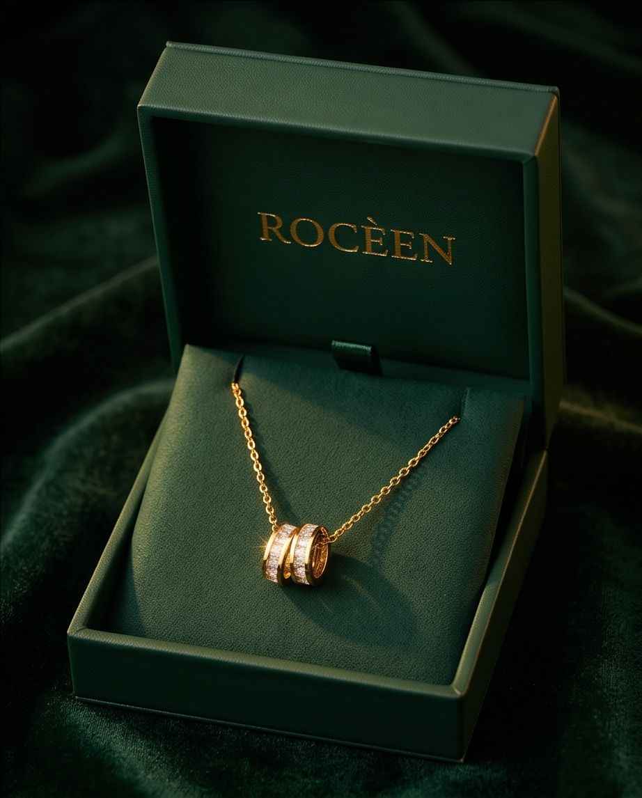 Gold-tone chain necklace with interlinked ring pendant on green velvet box