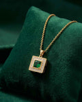 Gold square pendant necklace with green emerald-style center and crystal halo
