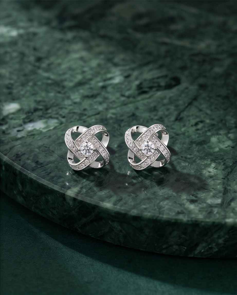 Sterling silver knot stud earrings with pavé settings and central round stones, pair