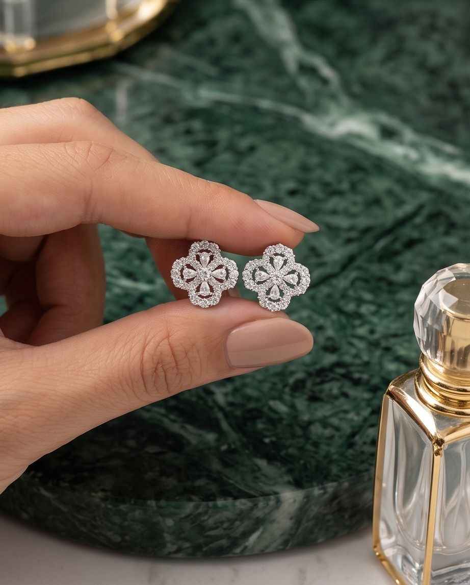 Flower diamond stud earrings on hand, glittering round stones in halo settings