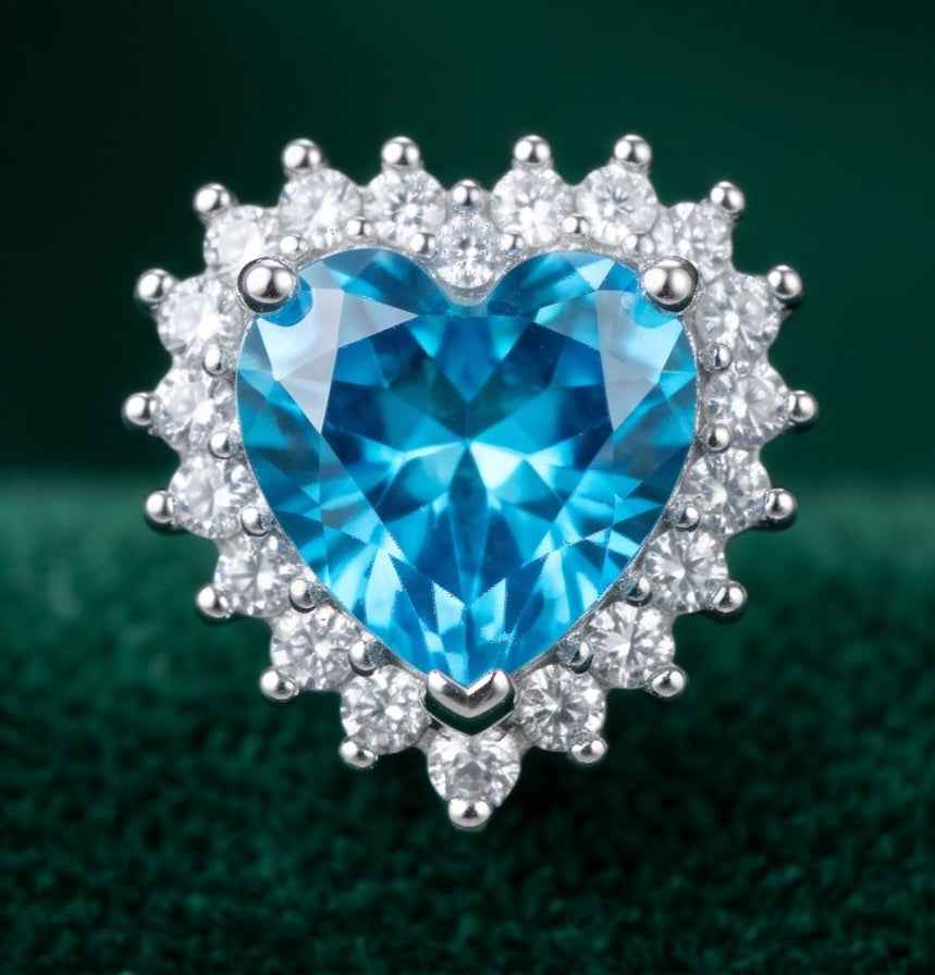 Heart-shaped blue gemstone halo stud earring with clear stones on silver-tone frame