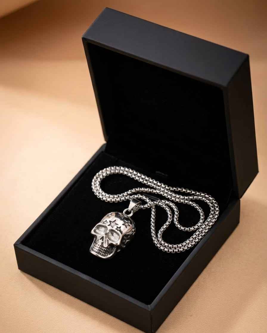 Skull charm necklace with star-eyed face pendant and layered silver chain in box
