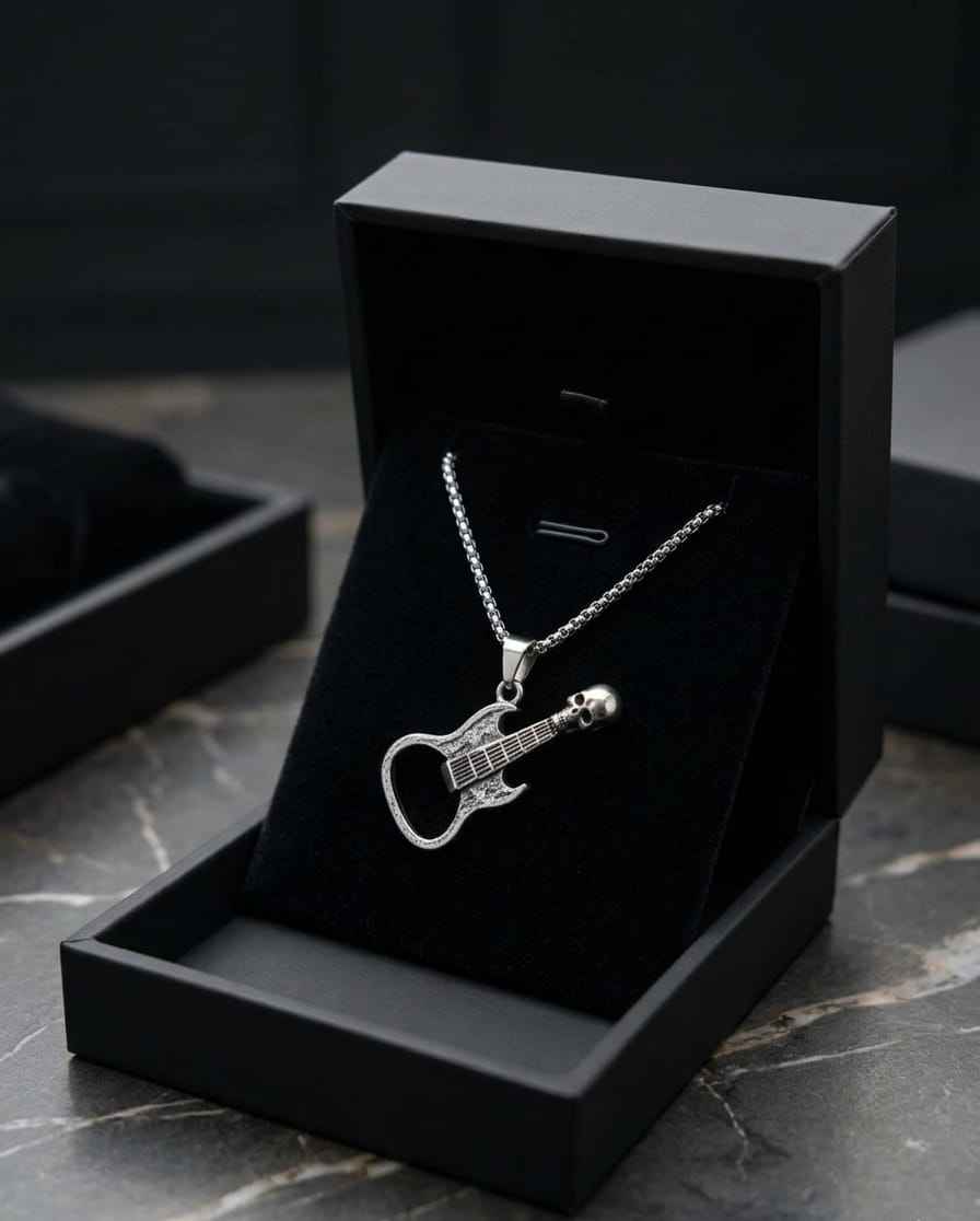 Silver chain guitar pendant necklace resting in black display box on stone surface