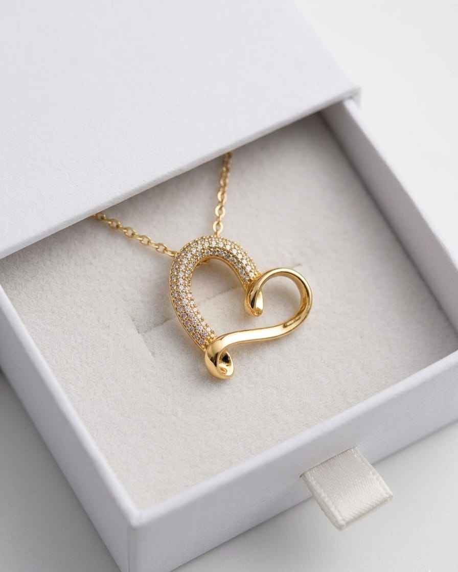 Gold-tone pavé curve heart necklace pendant on chain, shown in box
