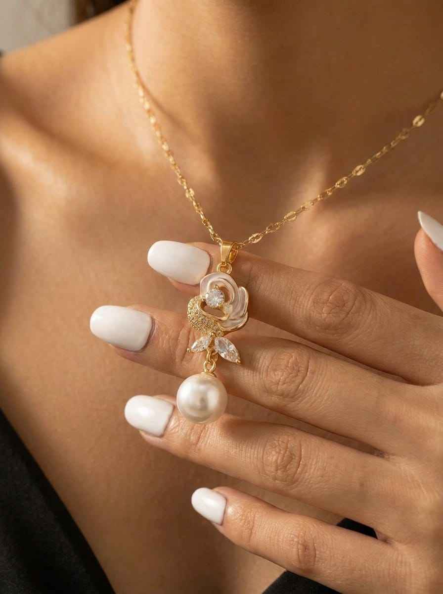 Gold-tone bloom necklace detail with pearl drop and sparkling flower pendant