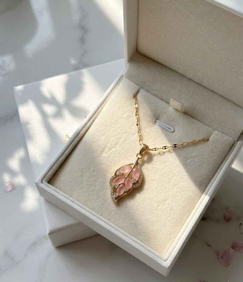 Gold leaf pendant necklace with pink teardrop stones and glittery details
