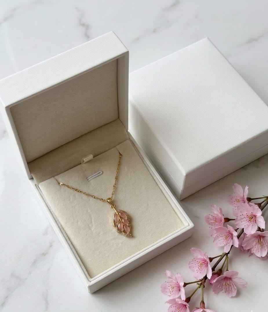 Gold leaf pendant necklace with pink teardrop stones on a thin chain