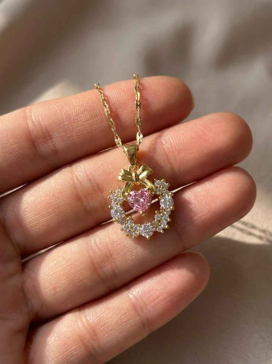 Gold-tone pendant necklace with round pink center stone and clear halo