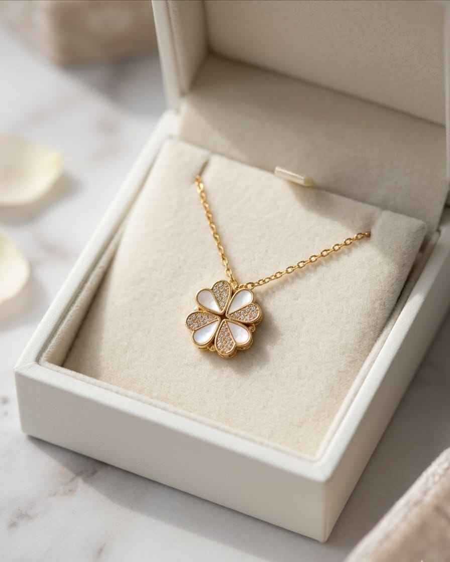 Gold-tone flower pendant necklace with white enamel center and sparkling stones