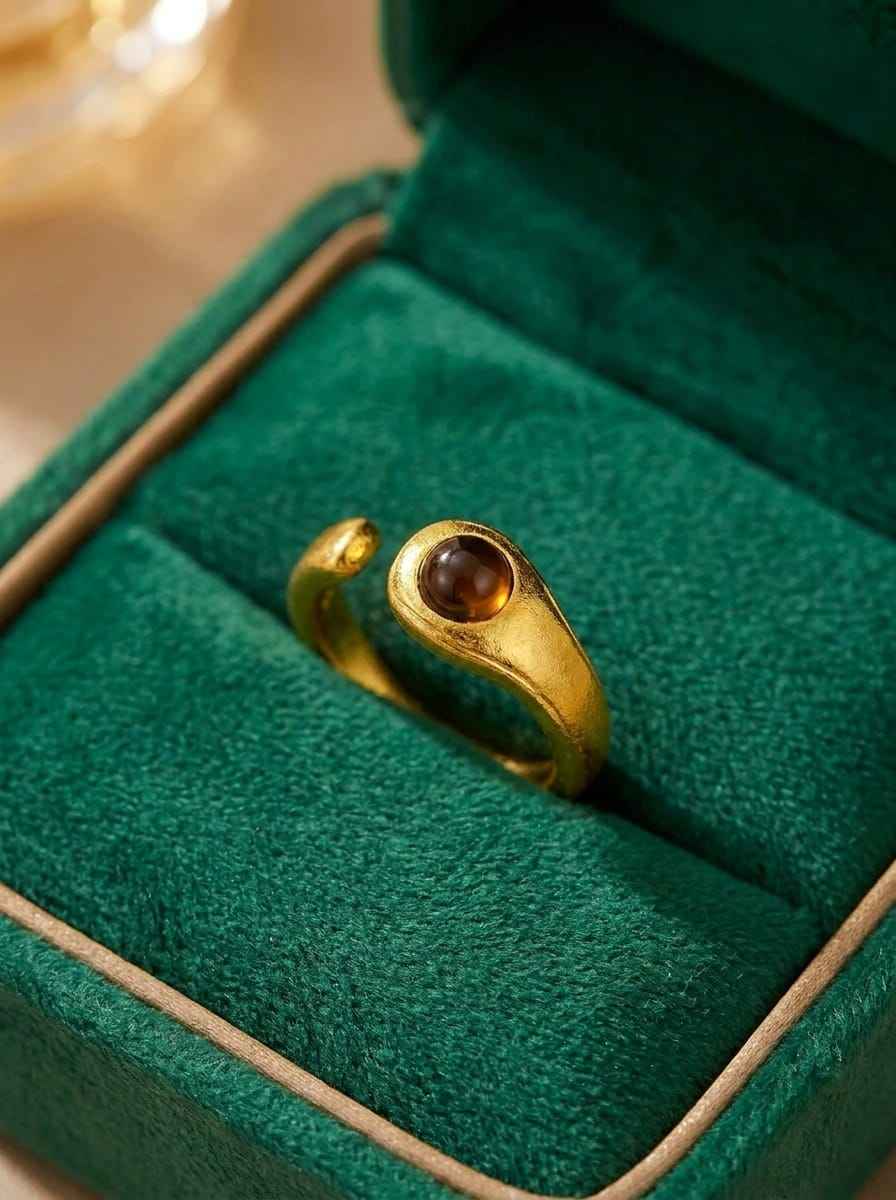Gold 925 ring with round dark brown stone bezel on velvet display