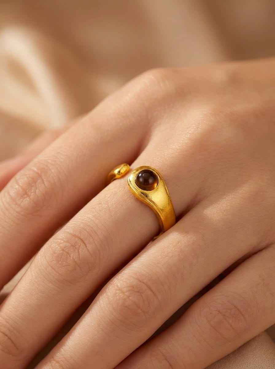Gold 925 ring with round dark brown stone bezel on slim band, close-up