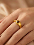 Gold 925 ring with round dark brown stone bezel on slim band, close-up