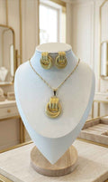 Gold-tone sculpted knot necklace set with pendant and stud earrings