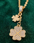 Gold clover drop necklace with pavé crystal detailing and dangling charm.
