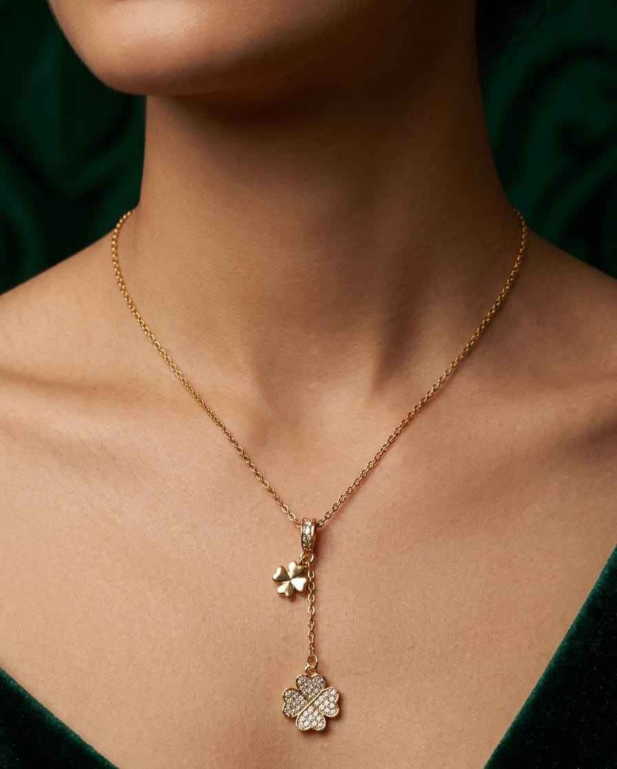 Gold clover pendant necklace worn close-up with pavé four-leaf drop charm.