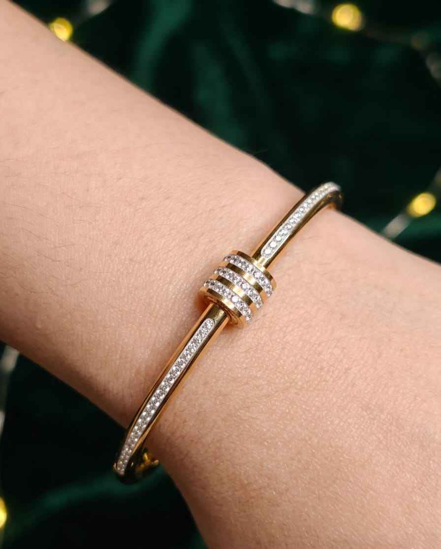 Gold open bangle on wrist with stacked pavé crystal bands