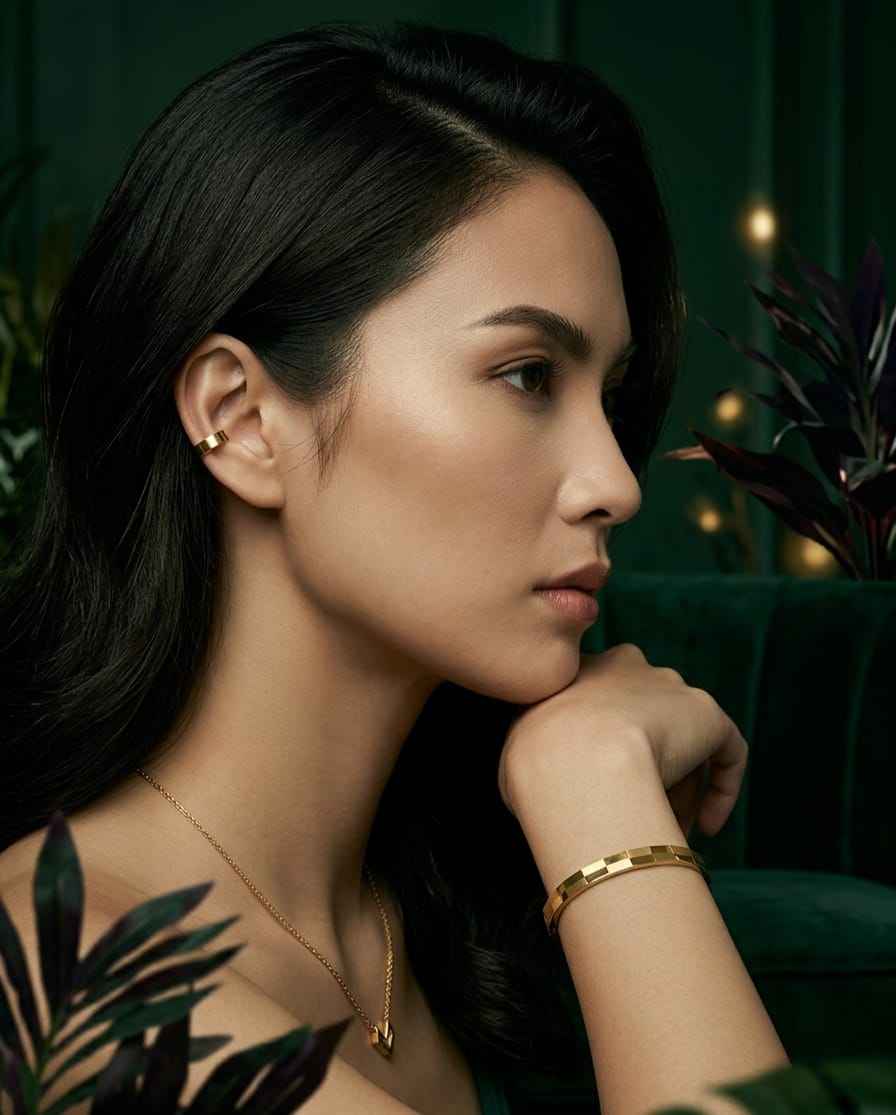 Gold faceted bangle bracelet worn on wrist, square-cut checker design visible.