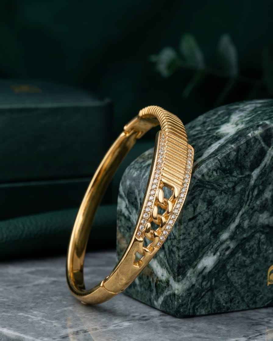 Gold statement bangle with pavé crystal center and ridged textured bracelet cuff.