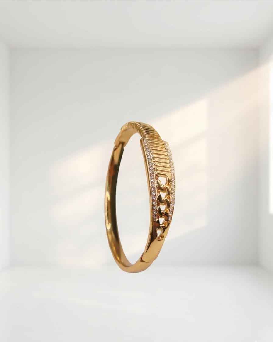 Gold textured statement bangle with pavé crystal row and open cuff profile.