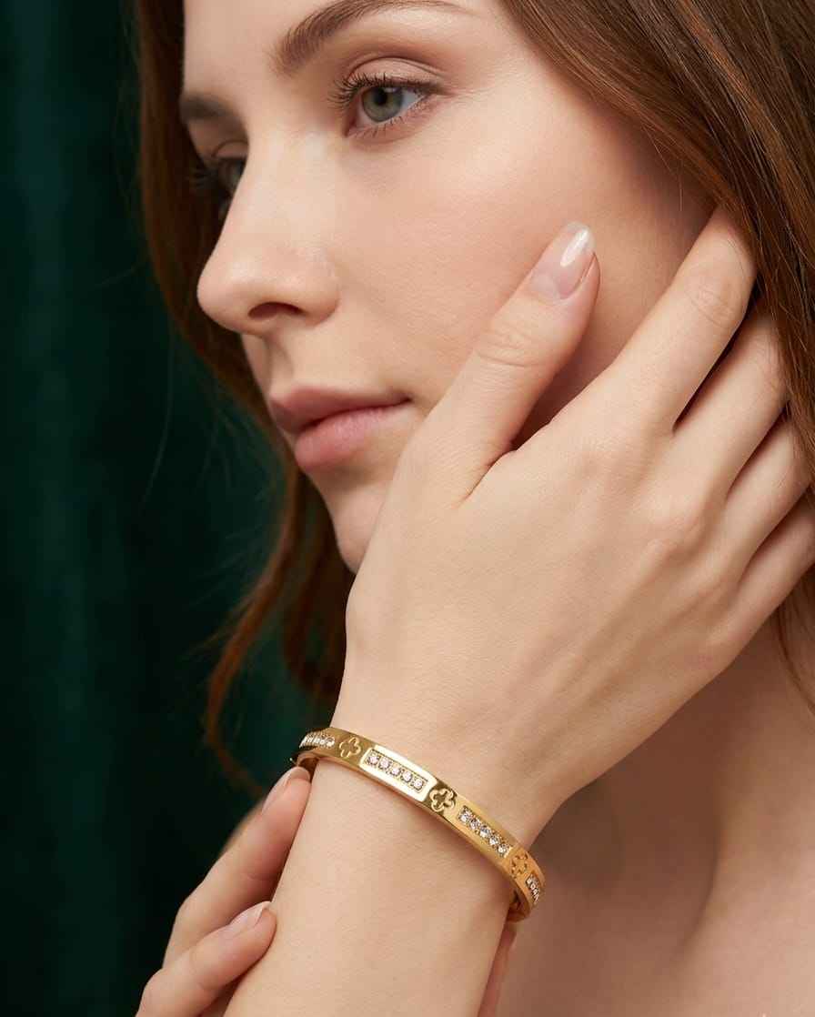 Gold-tone clover pavé bangle worn on wrist with clover and stone detail