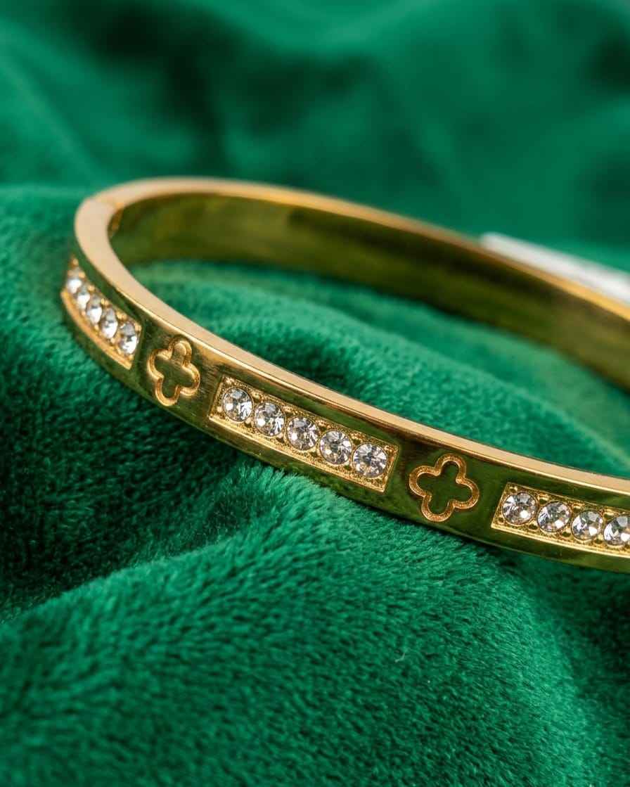 Gold clover pavé bangle with four-leaf motifs and small round stone rows