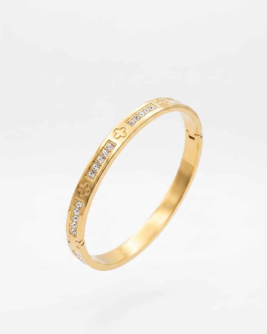 Gold-tone clover pavé bangle with raised clover symbols and clear stones