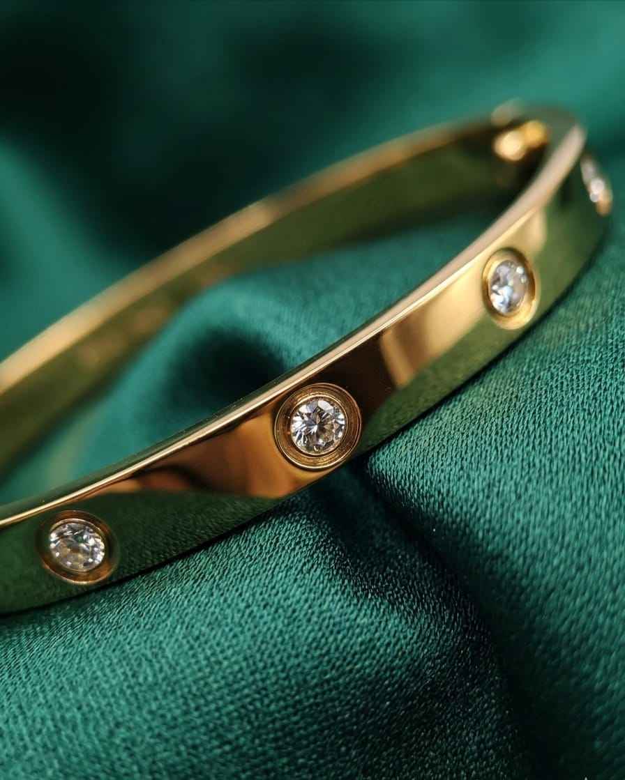 Gold bezel diamond bangle with three round diamonds along the front