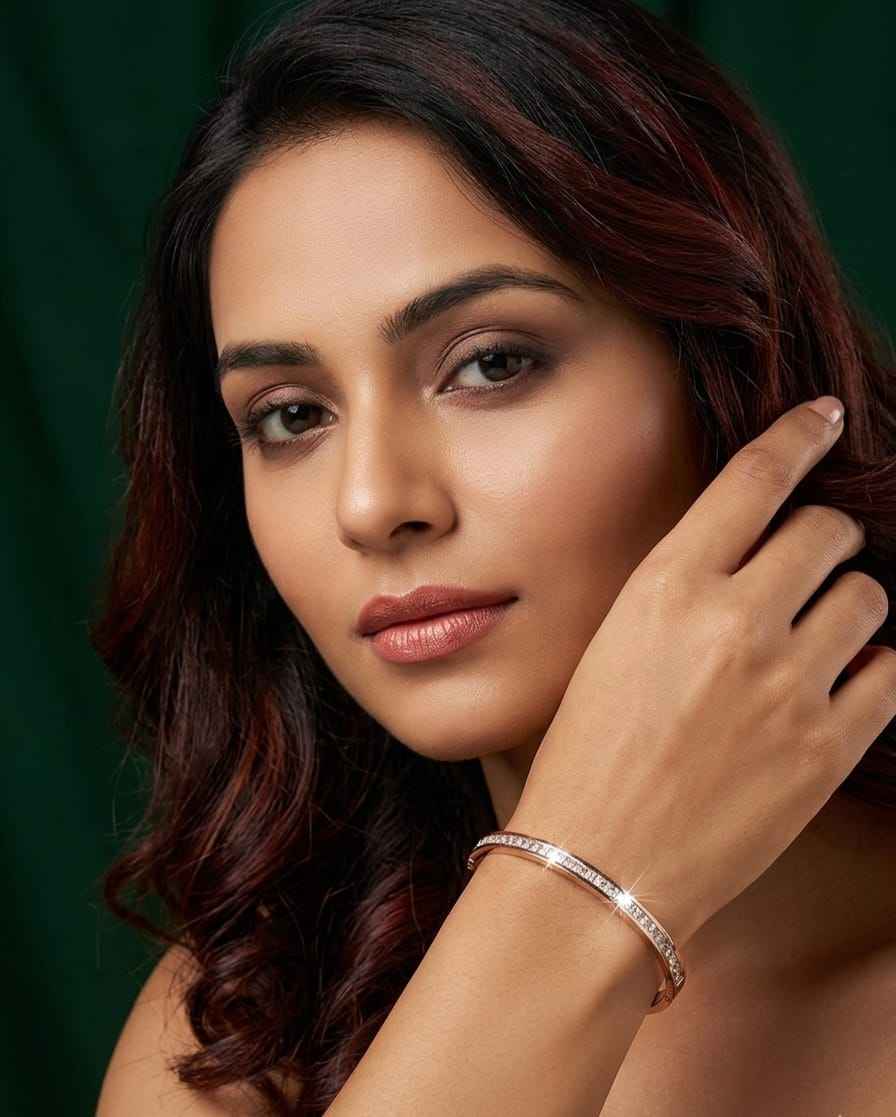Rose gold pavé bangle worn on wrist, single row of clear stones