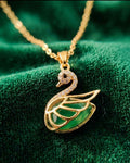 Gold swan pendant necklace with green jade-style enamel on a delicate chain.