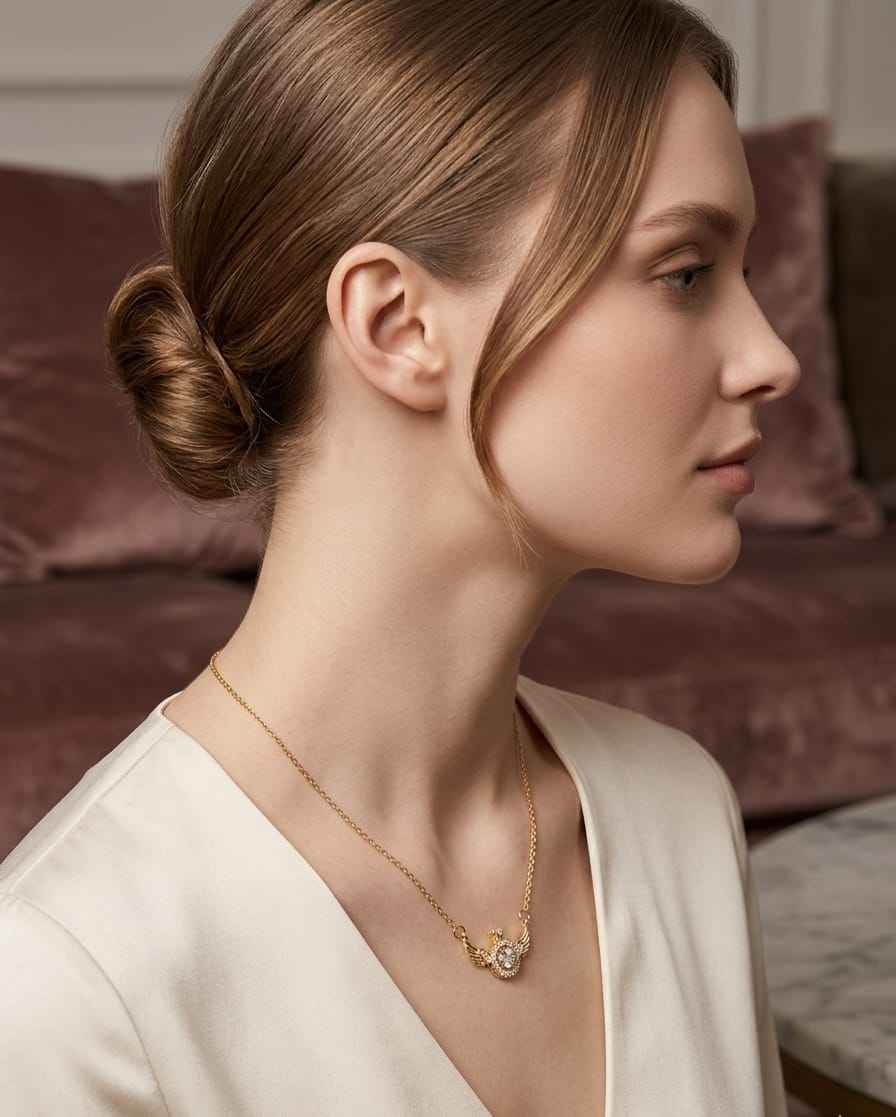 Gold winged halo pendant necklace worn with short collar-length chain