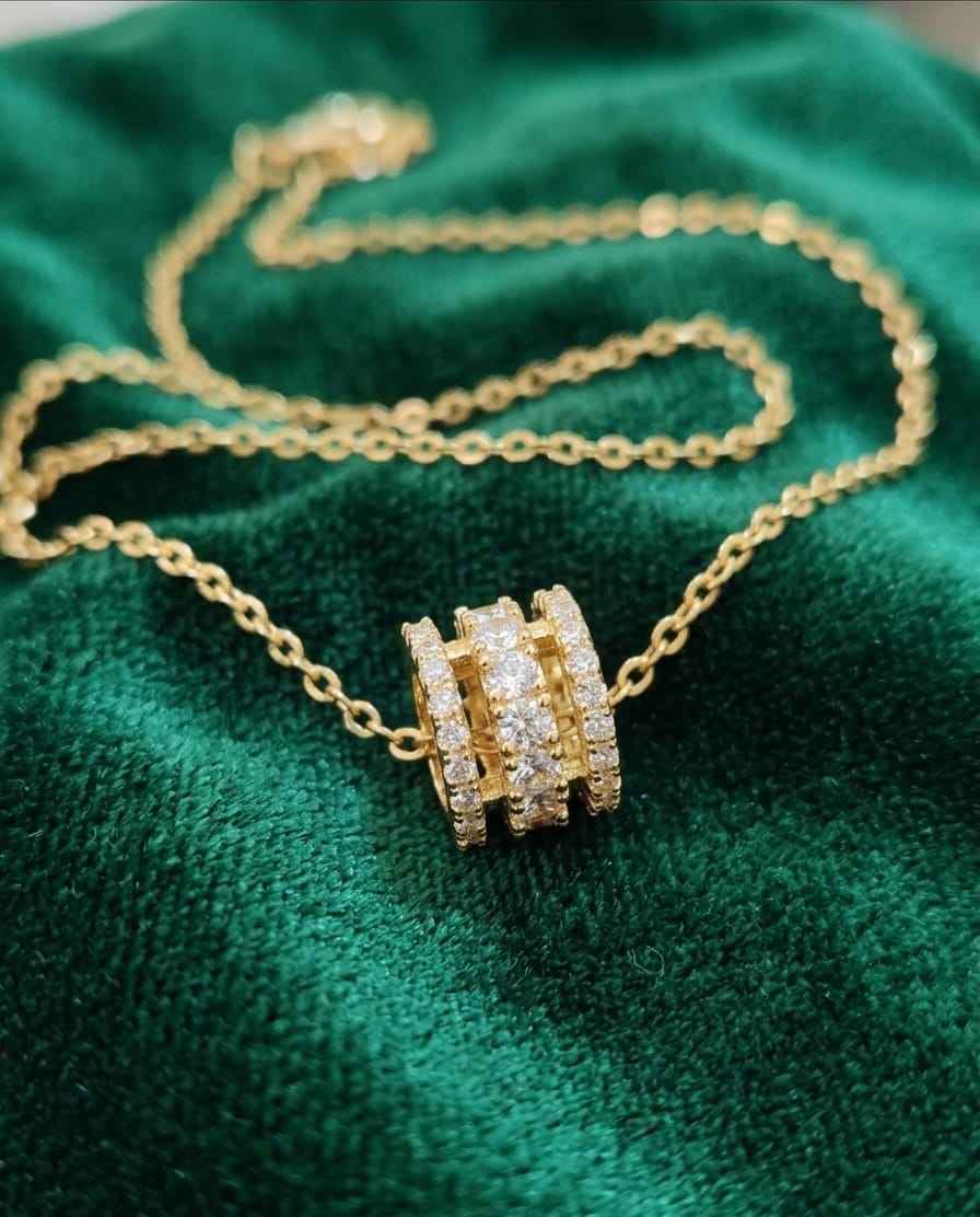 Gold-tone pavé bar necklace with rectangular crystal pendant on green velvet
