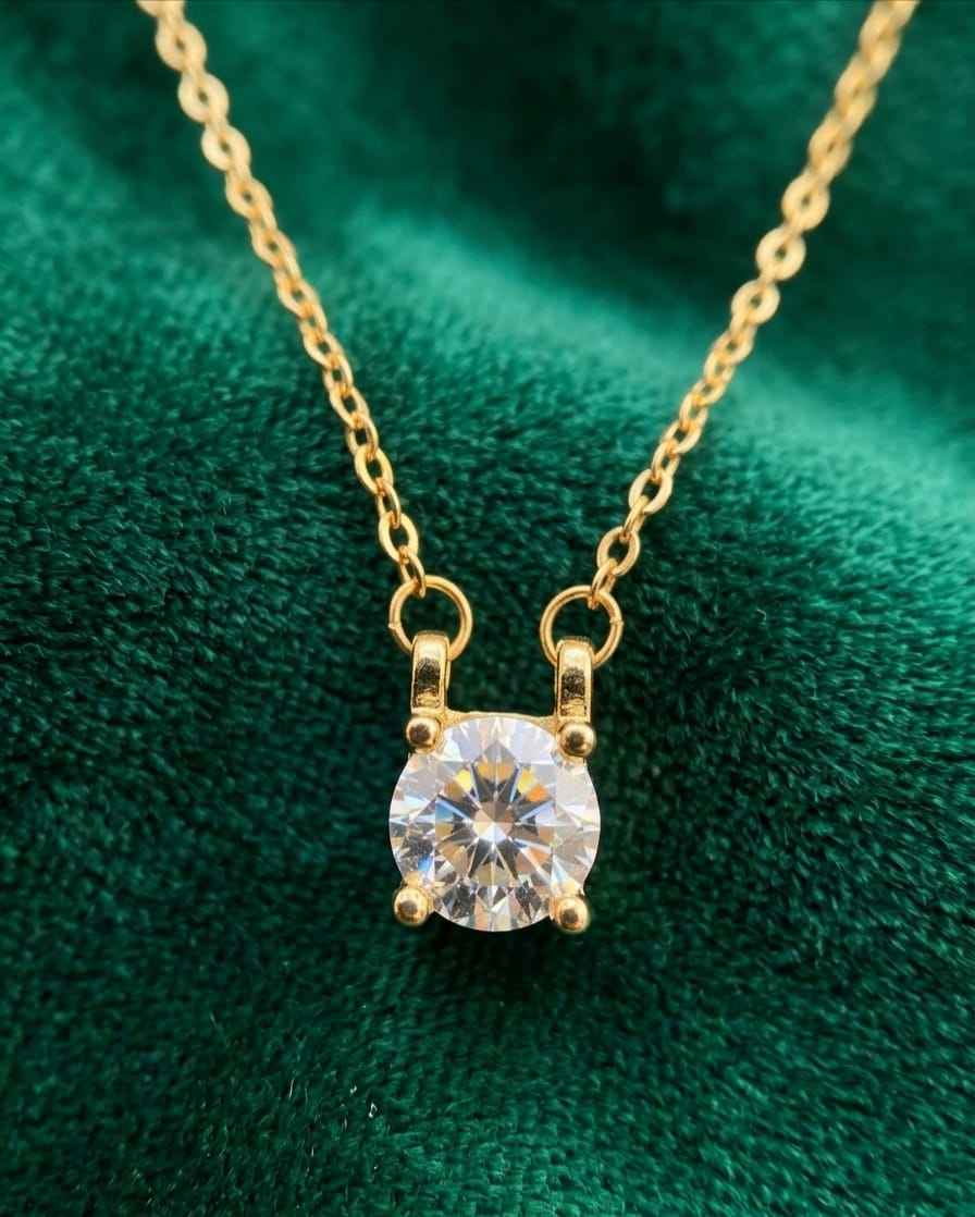 Gold chain necklace with round solitaire crystal pendant, close-up