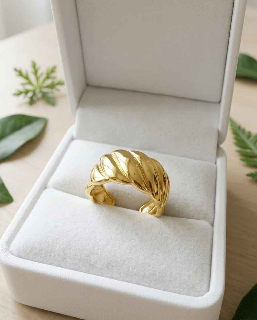 Gold sculpted cuff ring in a white jewelry box, twisted ridged wave design
